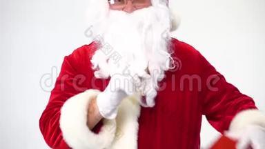 圣诞节。 圣诞老人在白色的背景上，带着一个带蝴蝶结的红色盒子，给它。 出席。